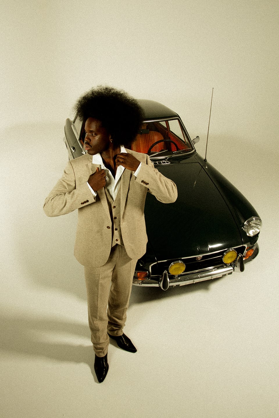 Photo d'un homme devant une voiture dans le studio